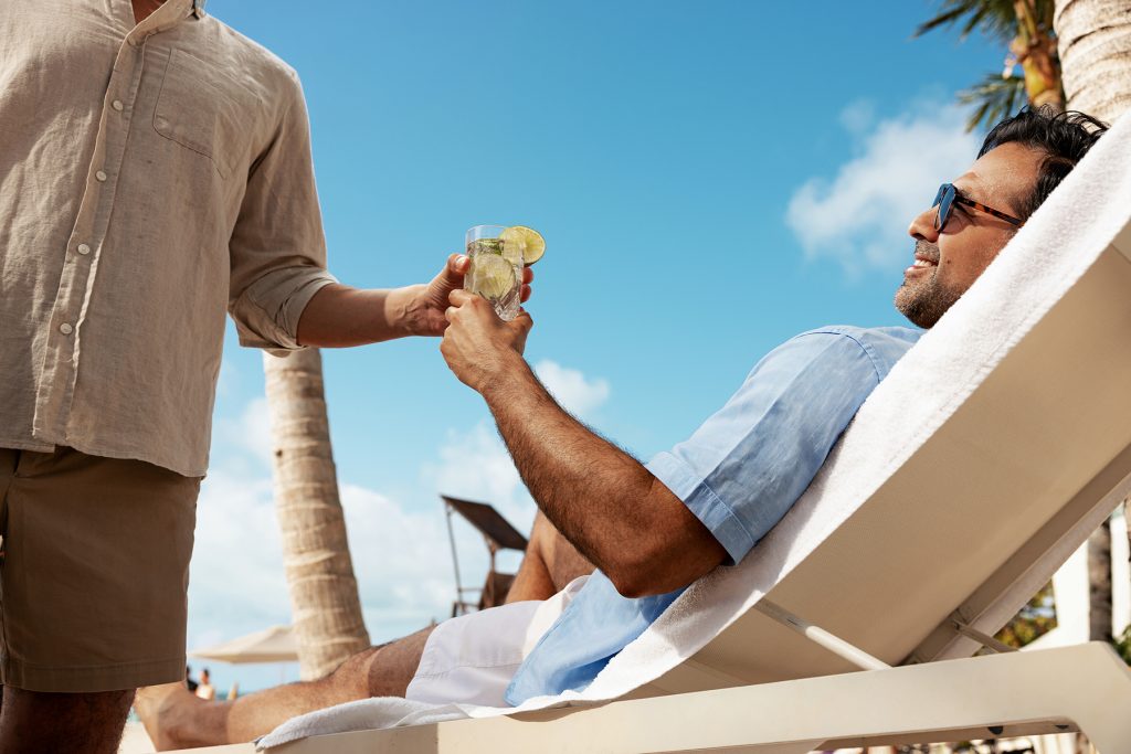 Amàre Cancún resort guest getting personal drink service on a lounger